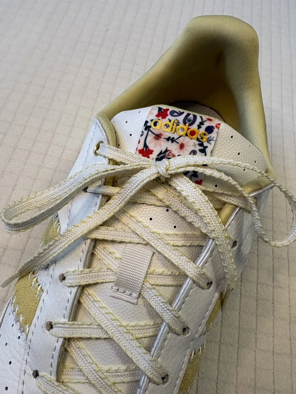 Adidas cream colored sneakers with floral accents